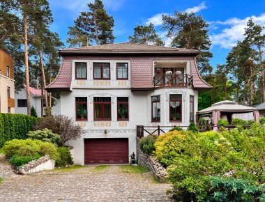 LATVIA, RIGA, HAZİRAN, 2022 - Vecaki, Riga, Letonya 'da yüksek çam ağaçlarıyla çevrili güzel bahçeli özel konut