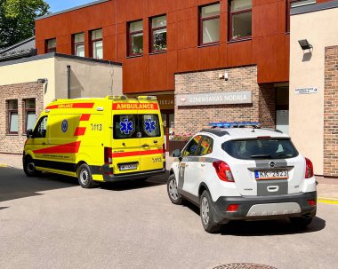 LATVIA, RIGA, HAZİRAN, 2022: Bir ambulans ve bir polis arabası Riga, Lavija 'daki Narkotik Merkezi' nin resepsiyon bölümünde ambulansa eşlik ediyor. Uzmanlar insanlara yardım eder.