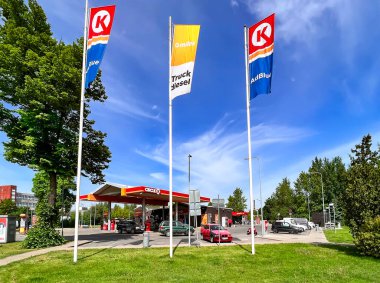 LATVIA, RIGA, MAYIS, 2022: Çevresi yeşilliklerle çevrili bir benzin istasyonu olan şehir altyapısı, Riga, Letonya 'da iyi korunmuş bir çevre gösteriyor