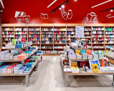 LATVIA, RIGA, HAZİRAN, 2022: Alışveriş merkezindeki kitaplıklarda farklı yazarların kitapları bulunan modern kitapçı iç mimarisi. Riga, Letonya