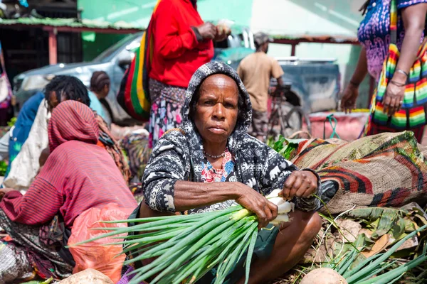 INDONESIA, PAPUA NEW GUINEA, WAMENA, İRYAN JAYA, 20 AĞUSTOS 2019: Papuan kadını Wamena, Yeni Gine, Endonezya 'da sokak pazarında sebze satıyor.