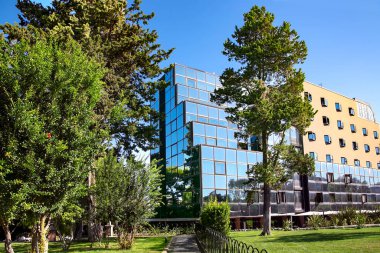 Cam panelli modern binaların mimarisi. Yapısal cam duvar mavi gökyüzünü yansıtıyor. Çağdaş mimari arka plan.