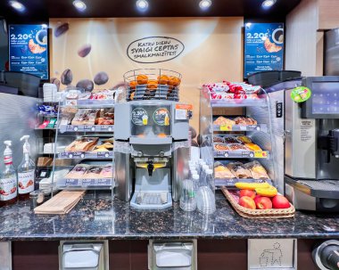 LATVIA, RIGA, HAZİRAN, 2022: farklı hamur işleri ve fast food aperatifleriyle birlikte kahve ve taze meyve suyu makinesi. Fast food konseptini kullan. Teslimat konseptini kaldır.