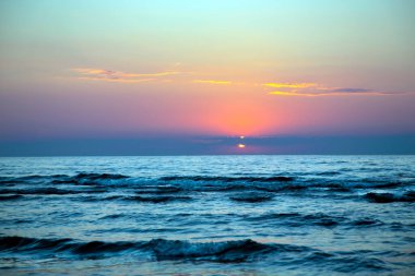 Letonya, Jurmala 'da Baltık Denizi üzerinde güzel bir gün batımı. Deniz batımı manzaralı. Güzel turuncu ve sarı deniz batımı.