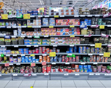 LATVIA, RIGA, JULY, 2022: Big section of canned fish from tuna and mackerel various manufacturers in a grocery department RIMI supermarket. Riga. Latvia