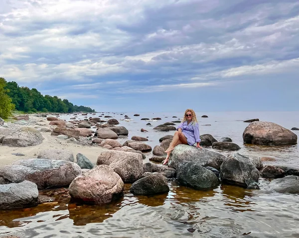 Mulher Bonita Com Cabelo Encaracolado Senta Uma Pedra Granito Praia — Fotografia de Stock