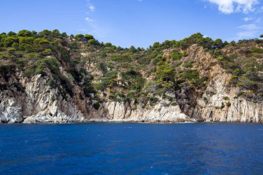 Mediterranean sea with rocky coast in Lloret de Mar located in popular Costa Brava, Catalonia, Spain. Amazing rock cliff seascape in the coastline.