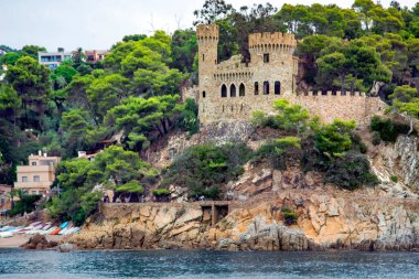 İspanya, Katalonya, Lloret de Mar, Eylül 2021: İspanya 'nın Lloret de Mar kentindeki Akdeniz kıyısında antik Sant Joan kalesi ve kozalaklı ağaçlarla dolu güzel kayalar, Kosta Brava, İspanya