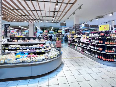 LATVIA, RIGA, JULY, 2022: Gastronomy department with a large selection of cheeses and quality wines in the RIMI hypermarket in Riga, Latvia. Retail industry. Grocery shopping. Food quality.