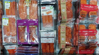 İspanya, BARCELONA, MARCH, 2022 - Vacuum plastik paketi dilimlenmiş salam Pamplona sucuğu ve farklı süpermarketlerden tütsülenmiş jambon, Riga. Letonya
