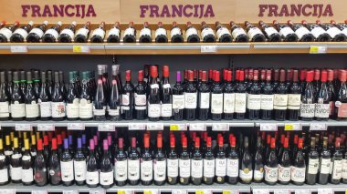 LATVIA, RIGA, JULY, 2022 - Interior of modern wine boutique store with vintage style wooden luxury showcases. Shelves with various of wines from France vineyards in the shopping mall