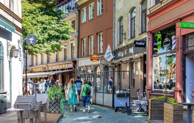 LATVIA, RIGA, AUGUST, 2022: Tourists on Jauniela street in Riga Old Town. Beautiful old street of Riga with low houses and cozy street cafes.
