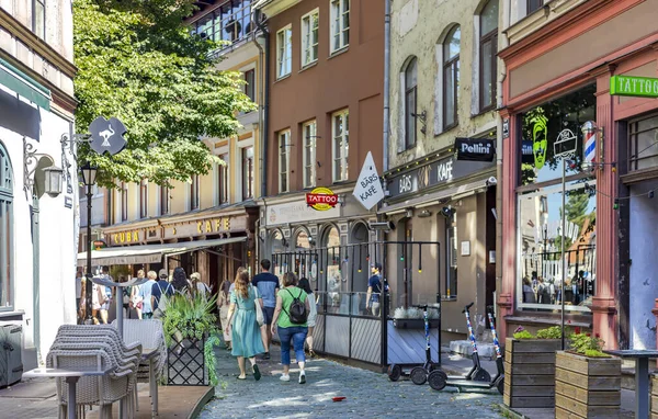 LATVIA, RIGA, AUGUST, 2022: Tourists on Jauniela street in Riga Old Town. Beautiful old street of Riga with low houses and cozy street cafes.