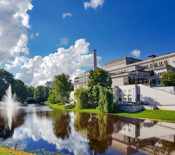 Building of the Latvian National Academic Opera and Ballet Theatre reflected in the water of the Riga city canal with a fountain in Riga, capital of Latvia, EU