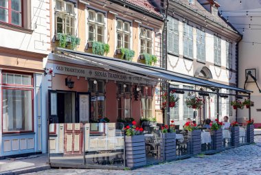 LATVIA, RIGA, AUGUST, 2022: Beautiful old street of Riga with low houses and cozy street cafes. Riga city historical centre is a UNESCO World Heritage Site