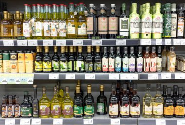 Latvia, Riga, August, 2022 - Shelves with variety brand of high quality extra virgin olive and sunflower oil in the shopping mall in Riga, Latvia.