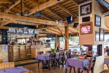 LATVIA, RIGA, AUGust, 2022: Riga, Letonya 'daki Daugava nehrinin kıyısında, Andrejosta' nın merkezinde ahşap tavanlı şık bir köy kafesi ve şömine