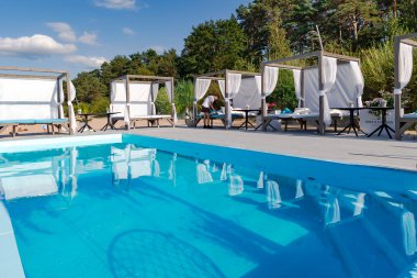 LATVIA, JURMALA, AĞUSTOS, 2022 - Letonya 'nın Jurmala kentindeki Baltık Denizi sahilinde yüzme havuzu yakınında dinlenmek için gazebos. Jurmala 'da sağlıklı ve spor yaşam tarzı ve aktiviteleri.