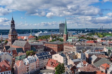 LATVIA, RIGA, SEPTEMBER, 2022: Riga Old Town 'daki Saint Peters kilisesinden hava manzarası ve Daugava nehrindeki rıhtımdaki büyük yolcu gemisi. - Letonya. AB.