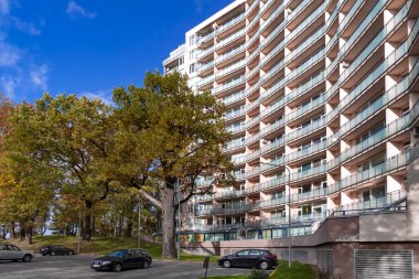 LATVIA, RIGA, SEPTEMBER, 2022 - Riga, Letonya 'da bir meşe parkı ile çevrili modern çok katlı konut binası. Konutlar ve ofisler için çağdaş çok katlı mimari planlanıyor.