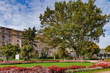 LATVIA, RIGA, ECTOBER, 2022: Güneşli bir sonbahar gününde, insanlar Riga, Letonya 'daki Letonya Ulusal Operası yakınlarındaki güzel bir parkta dinleniyorlar.
