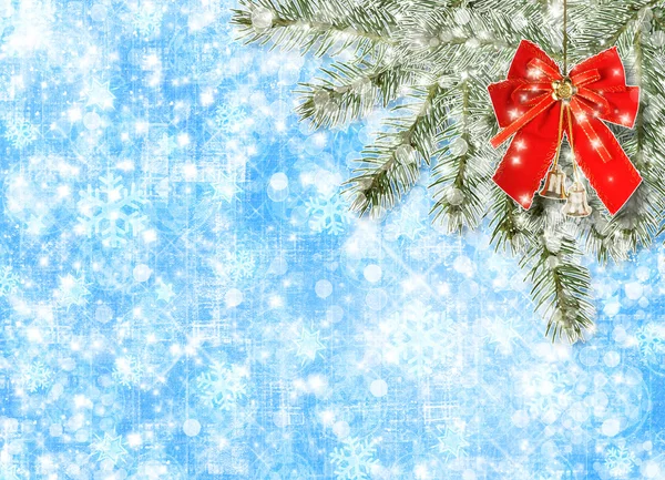 Weihnachtskugeln und rote Schleife mit Glöckchen auf dem Hintergrund schneebedeckter Tanne b — Stockfoto