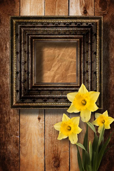 Old wooden frame for photo with bunch of flower narcissus — Stock Photo, Image