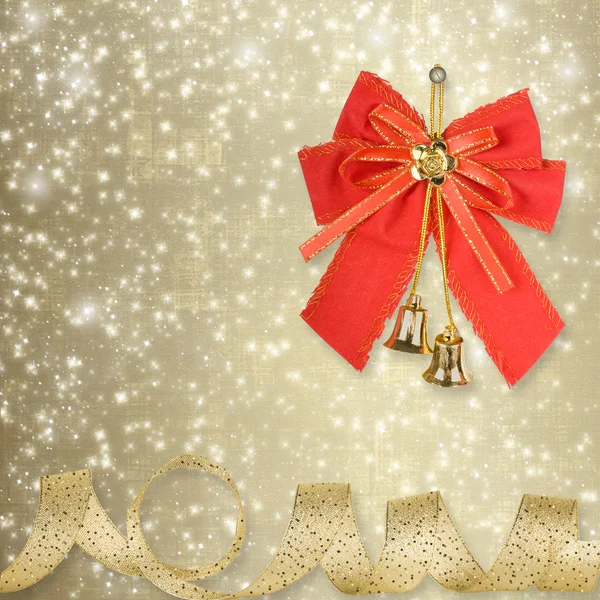 Red Christmas bow with golden bells on an abstract background — Stock Photo, Image