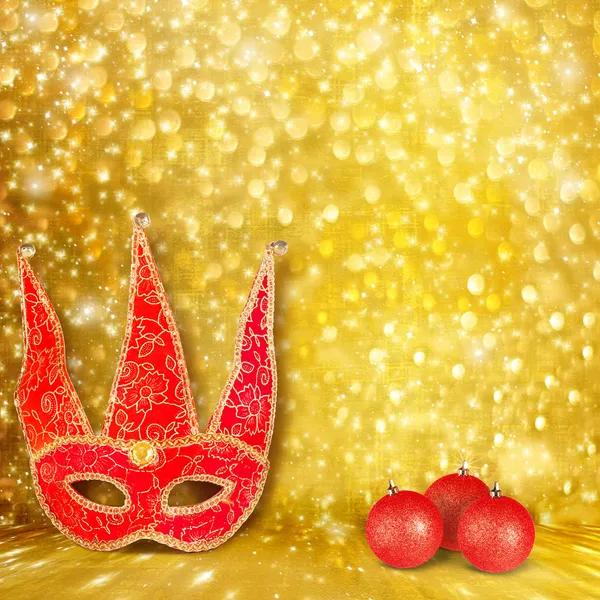 Maschera di Carnevale e una palla di Natale rossa su un dorato astratto indietro — Foto Stock