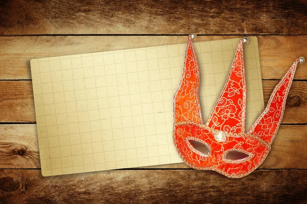 Maschera di carnevale rosso con vecchia carta per il saluto su backgrou di legno — Foto Stock