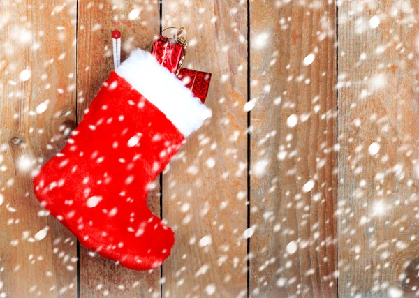 Bota de Navidad roja con regalos en la pared de madera de fondo —  Fotos de Stock