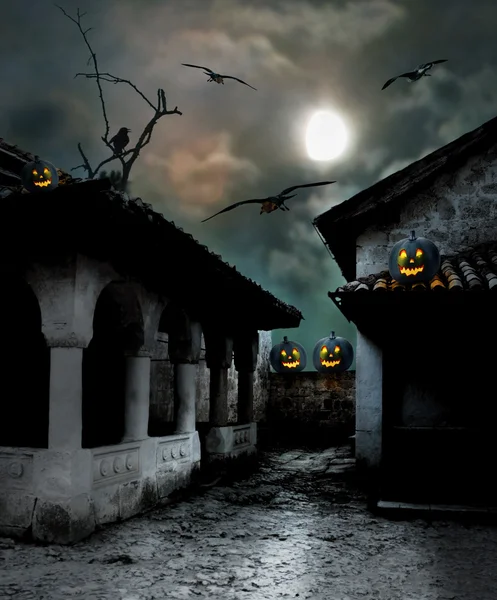 Halloween pumpkins in the yard of an old house at night in the b — Stock Photo, Image