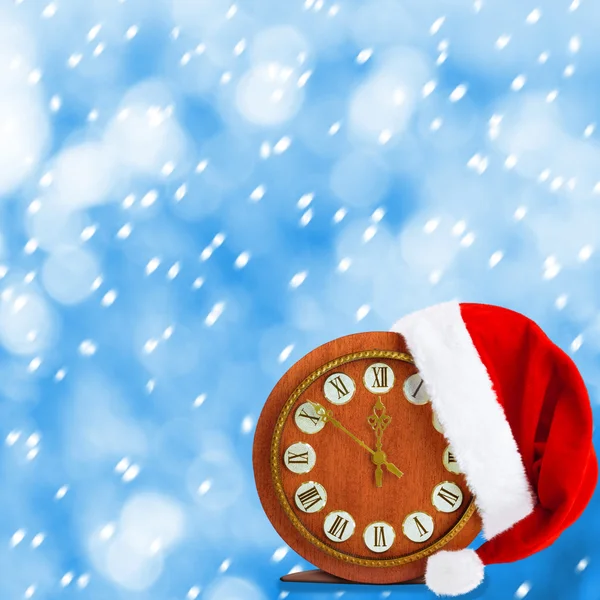 Sombrero y reloj de Papá Noel. Navidad noche nevada —  Fotos de Stock