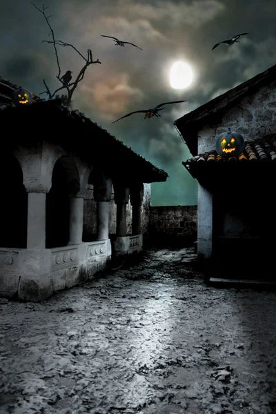 Calabazas de Halloween en el patio de una casa vieja por la noche en el b — Foto de Stock