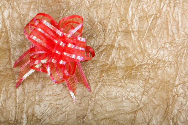 Schöne rote Schleife für Geschenkdekoration auf abstraktem Goldgrund — Stockfoto