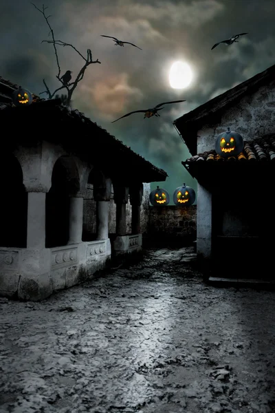 Halloween pumpkins in the yard of an old house at night in the b — Stock Photo, Image