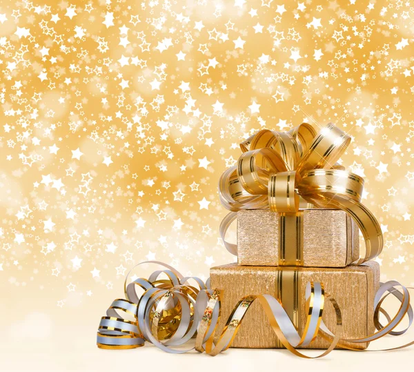 Geschenkbox in goldenem Geschenkpapier auf schönem abstrakten Hintergrund — Stockfoto
