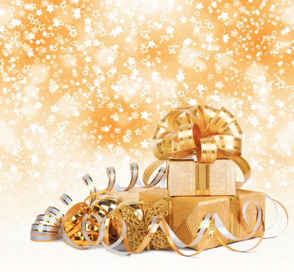 Gift box in gold wrapping paper on a beautiful abstract backgrou — Stock Photo, Image