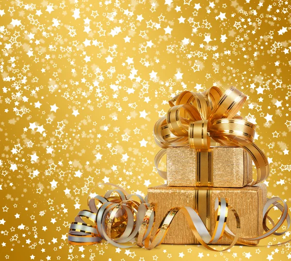 Geschenkbox in goldenem Geschenkpapier auf schönem abstrakten Hintergrund — Stockfoto