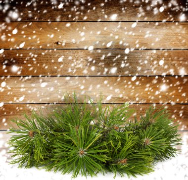 Snowy pine branch on the background of the old wooden walls clipart