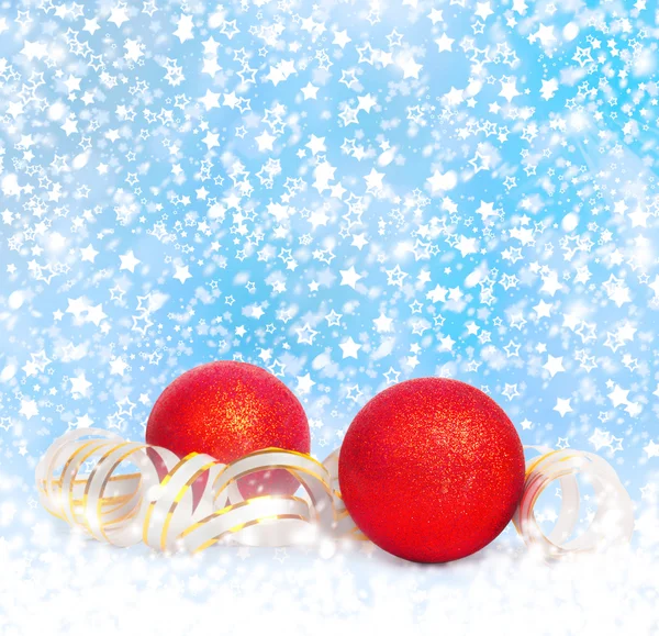 Czerwone bombki z złoty serpentyna na śnieżne backgro niebieski — Zdjęcie stockowe