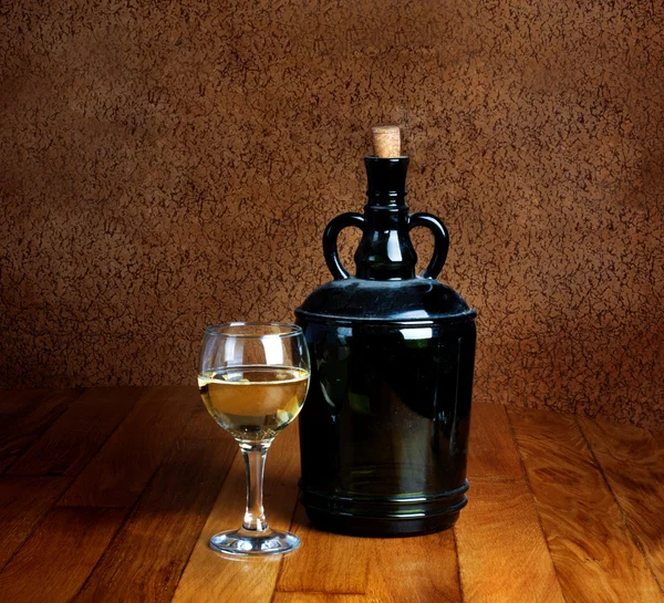 Dusty old bottle and glass of white wine — Stock Photo, Image