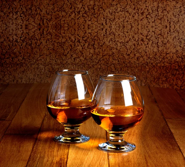 Dos copas de brandy en la encimera de madera vieja —  Fotos de Stock