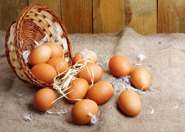 Huevos de pollo frescos en nido de paja sobre fondo de pared de madera —  Fotos de Stock