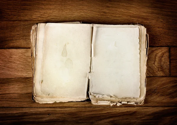 Offenes altes Buch mit leeren Textseiten auf einem alten Holztisch — Stockfoto