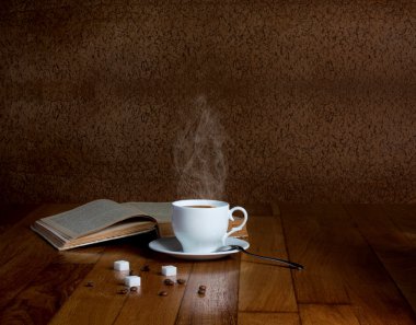 ahşap masa ve bir kitap yığını üzerinde taze kahve fincan sıcak