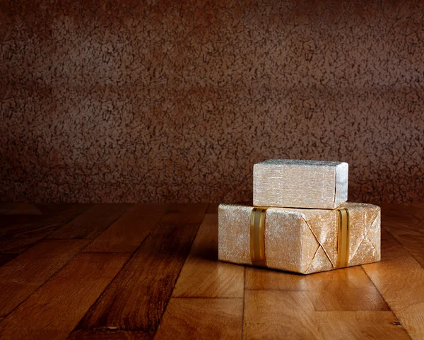 Caja de regalo en papel de regalo dorado con cinta sobre mesa de madera — Foto de Stock