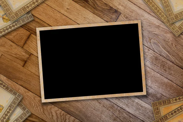 A stack of old postcards and frames on a wooden table — Stock Photo, Image