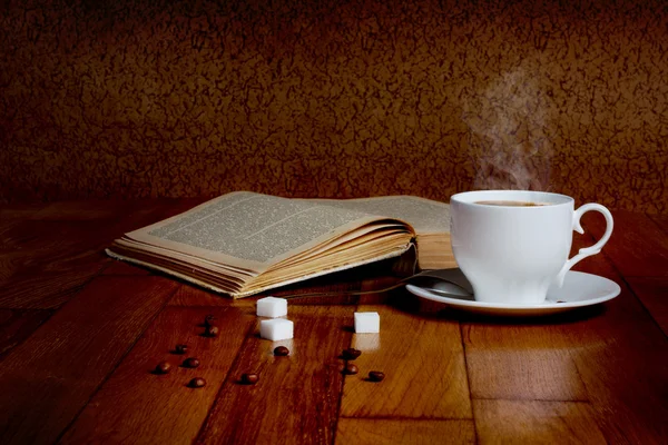 Tasse chaude de café frais sur la table en bois et une pile de livres — Photo