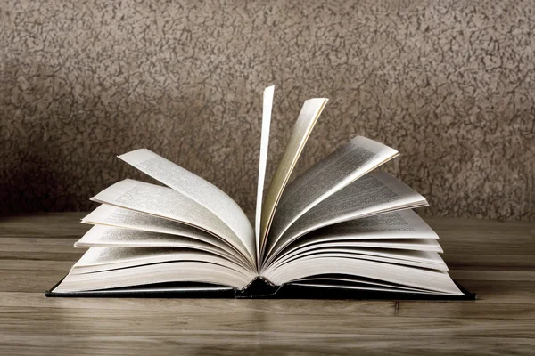 Old open book on grunge wooden table — Stock Photo, Image